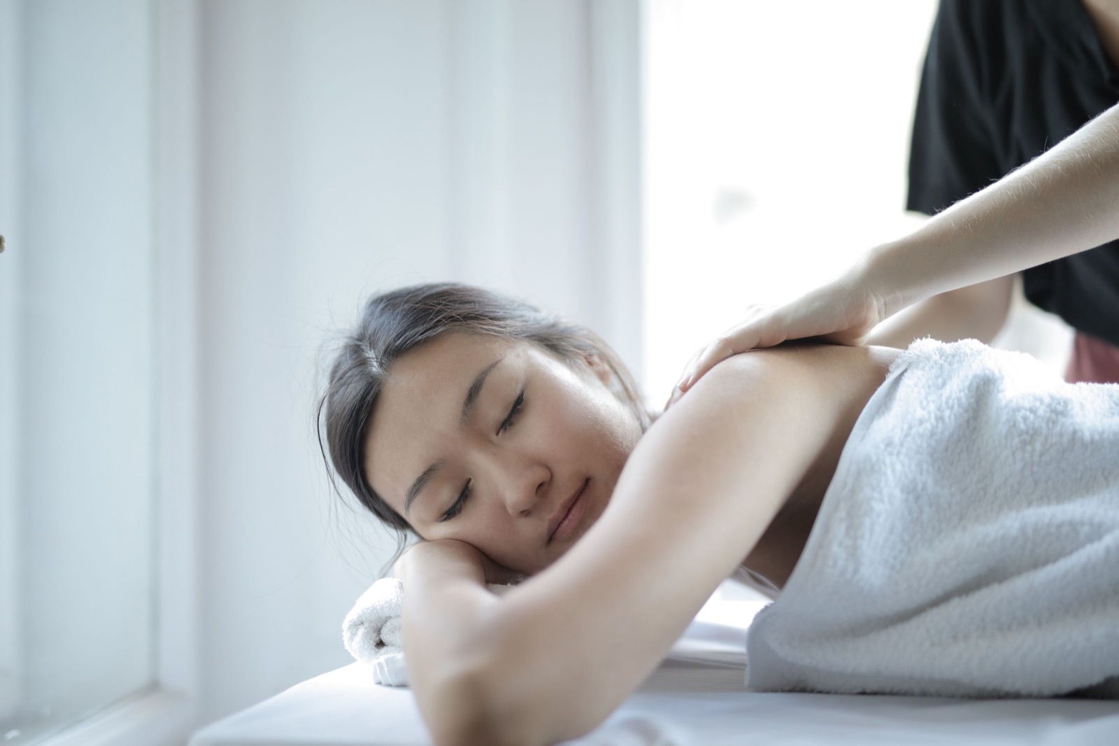 Therapists giving massages in a spa treatment room